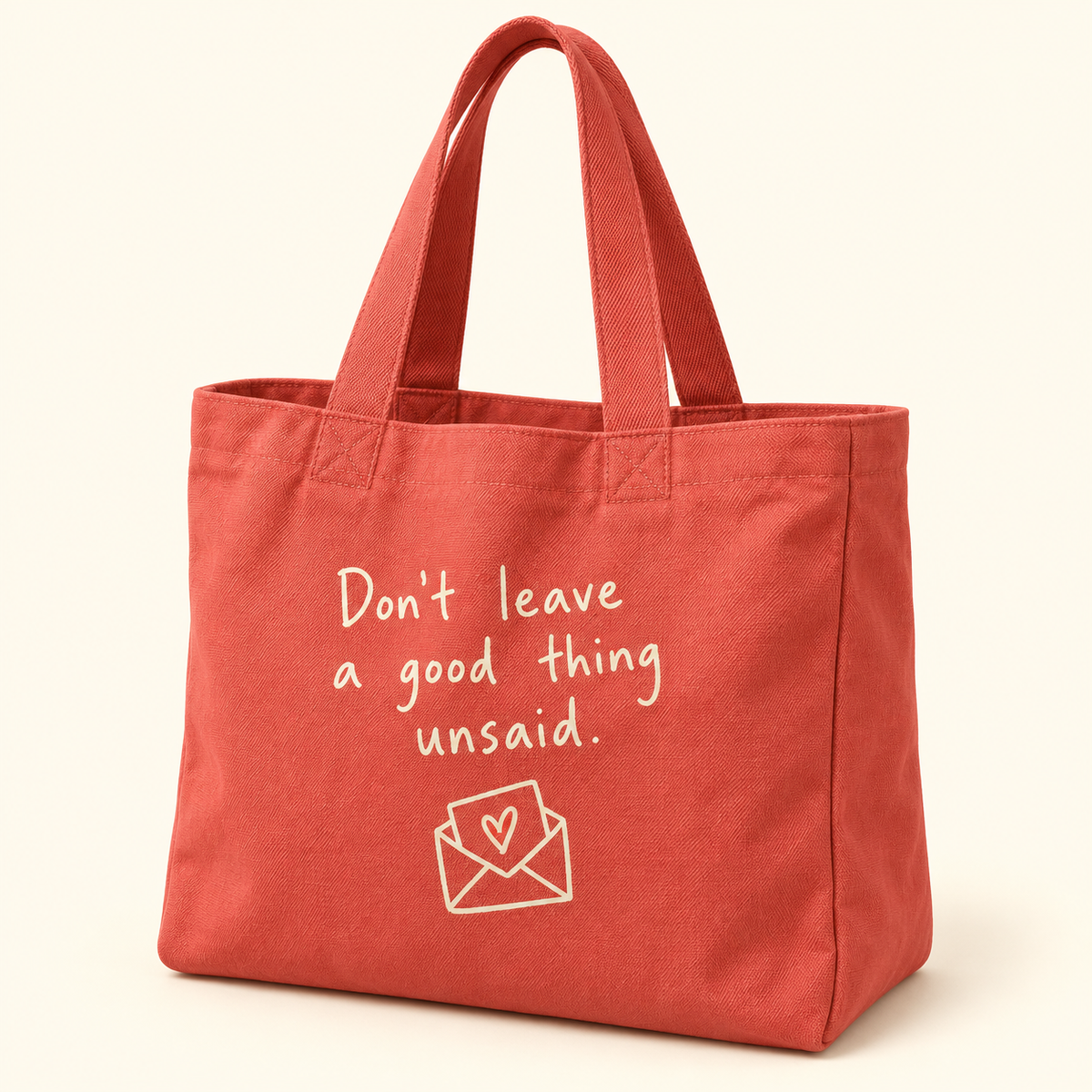 Coral tote with cream Don’t leave a good thing unsaid lettering and a heart-envelope illustration