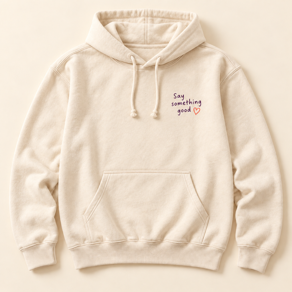 Front of cream hoodie with plum Say something good lettering and coral heart on chest