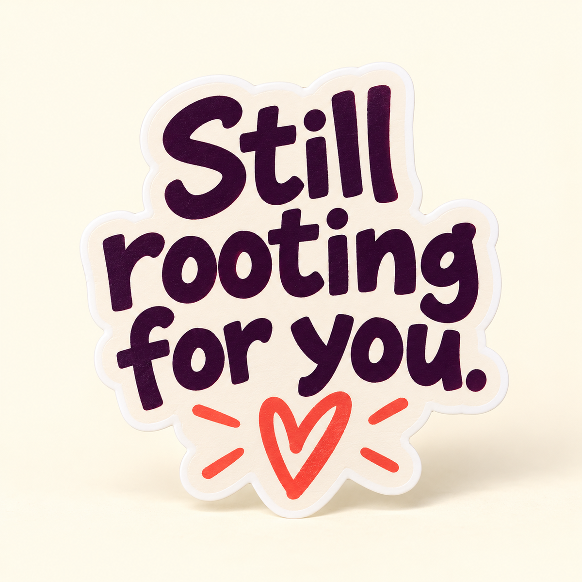Cream sticker with bold plum Still rooting for you lettering and a coral heart and accents